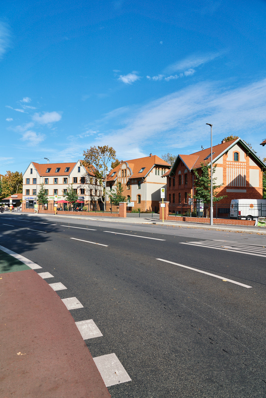 Gewerbe- und Büroensemble am S-Bahnhof Grünau, Richterstraße 11-15, Berlin, Straßenraum mit Denkmalgerecht sanierten Altbauten, im Hintergrund Bürohaus am Vorplatz